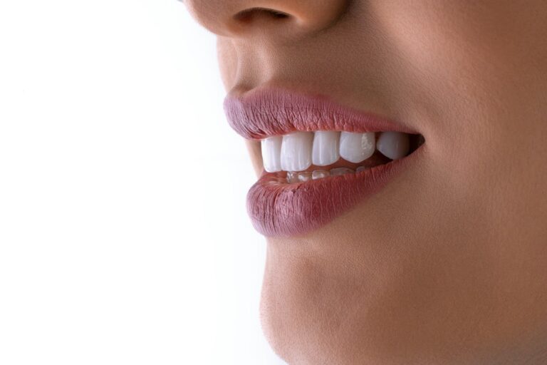 Person gently brushing around a dental implant crown beside floss and an interdental brush.
