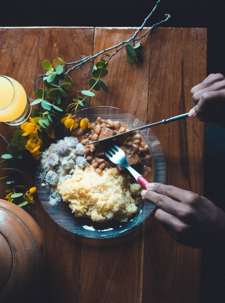 A person eating soft mashed food from a bowl beside a glass of water during dental implant recovery.
